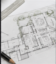 Hand-drafted residential floor plan with a scale ruler and pencil
